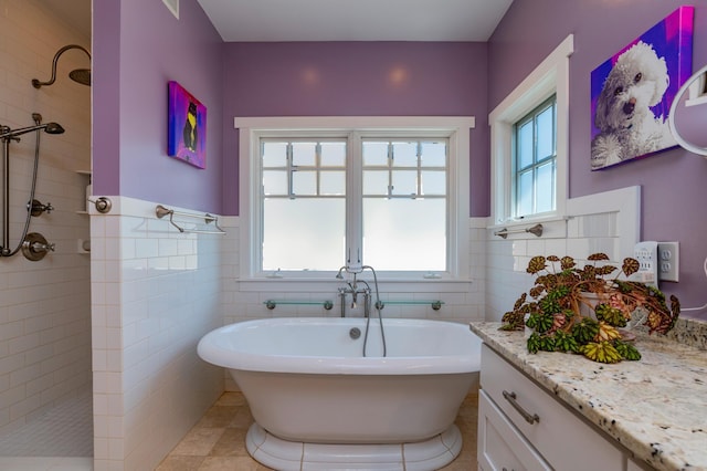 582 Summit Ave, Saint Paul, MN 55102 - full bathroom with a freestanding tub, a walk in shower, vanity, tile walls, and a wainscoted wall