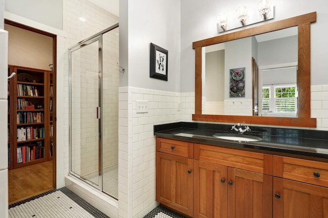 582 Summit Ave, Saint Paul, MN 55102 - bathroom featuring a shower stall, vanity, tile walls, a wainscoted wall, and tile patterned flooring