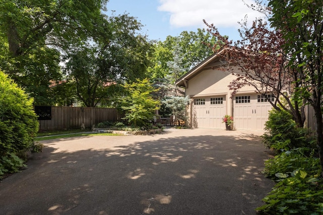 582 Summit Ave, Saint Paul, MN 55102 - view of home's exterior featuring asphalt driveway, stucco siding, and an attached garage