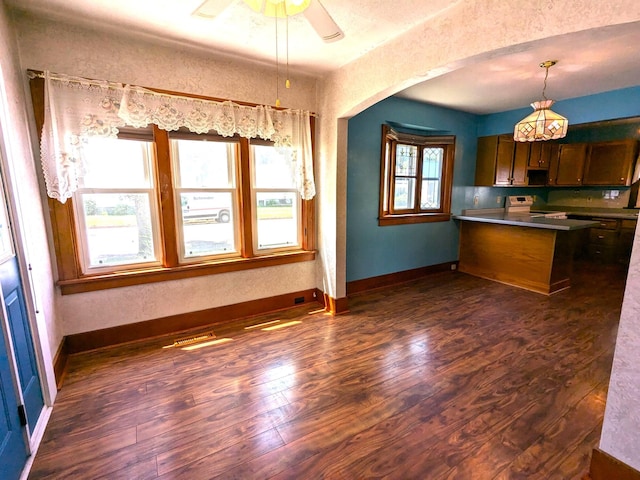 521 Chestnut St, Winona, MN 55987 - kitchen with range with electric cooktop, dark wood finished floors, a peninsula, arched walkways, and hanging light fixtures