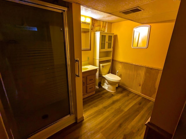 521 Chestnut St, Winona, MN 55987 - full bath featuring a shower stall, vanity, wainscoting, wood finished floors, and wooden walls