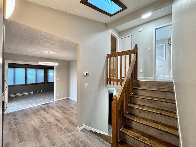 1414 Danube Rd, Fridley, MN 55432 - stairway featuring a baseboard radiator, wood finished floors, and a textured ceiling