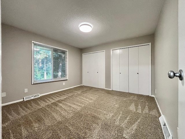 1414 Danube Rd, Fridley, MN 55432 - unfurnished bedroom with multiple closets, a textured ceiling, and carpet floors