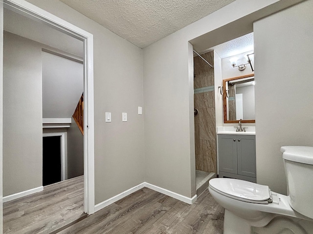 1414 Danube Rd, Fridley, MN 55432 - full bathroom featuring tiled shower, wood finished floors, vanity, and a textured ceiling