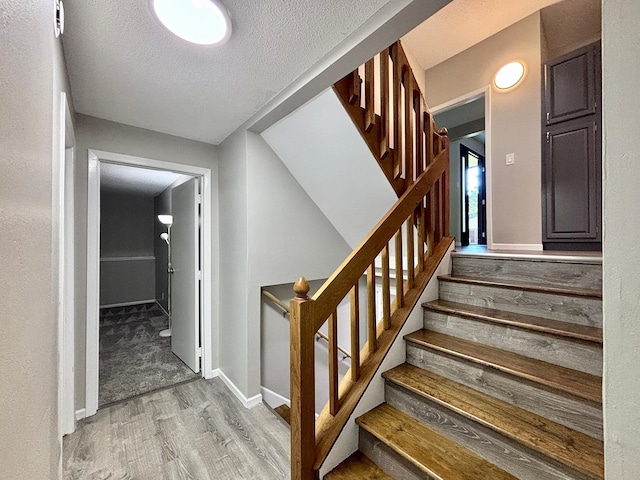 1414 Danube Rd, Fridley, MN 55432 - stairs featuring wood finished floors and a textured ceiling