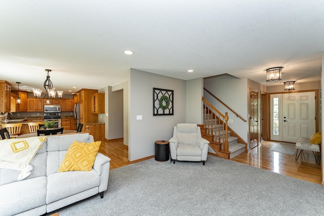 2944 Mayowood Common Cir SW, Rochester, MN 55902 - living area featuring stairway, a chandelier, light carpet, recessed lighting, and light wood finished floors