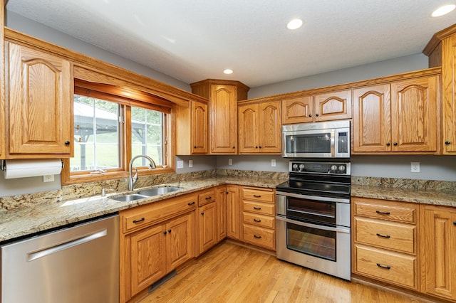 2944 Mayowood Common Cir SW, Rochester, MN 55902 - kitchen featuring stainless steel appliances, recessed lighting, light stone counters, and light wood-style floors