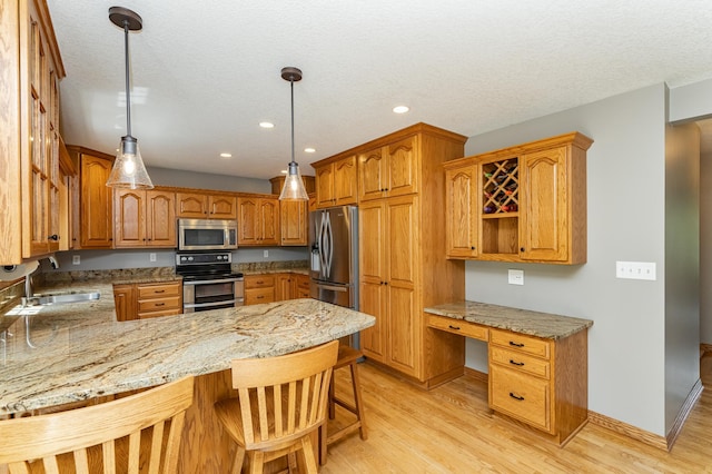 2944 Mayowood Common Cir SW, Rochester, MN 55902 - kitchen with appliances with stainless steel finishes, a peninsula, light wood-type flooring, light stone counters, and recessed lighting
