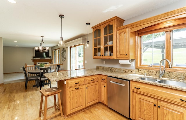2944 Mayowood Common Cir SW, Rochester, MN 55902 - kitchen featuring stainless steel dishwasher, a peninsula, light stone counters, glass insert cabinets, and light wood-style floors