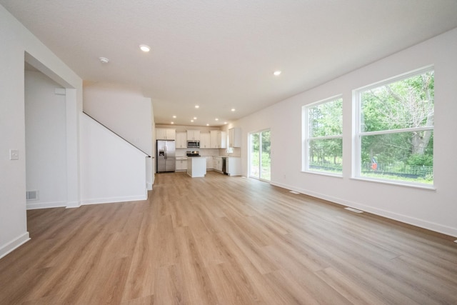 9706 Jasmine Ave NE, Hanover, MN 55341 - unfurnished living room featuring light wood finished floors and recessed lighting