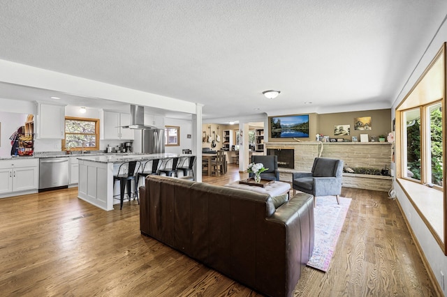 1281 Minnehaha Pkwy, Minneapolis, MN 55419 - living area with healthy amount of natural light, wood finished floors, a fireplace with raised hearth, and a textured ceiling