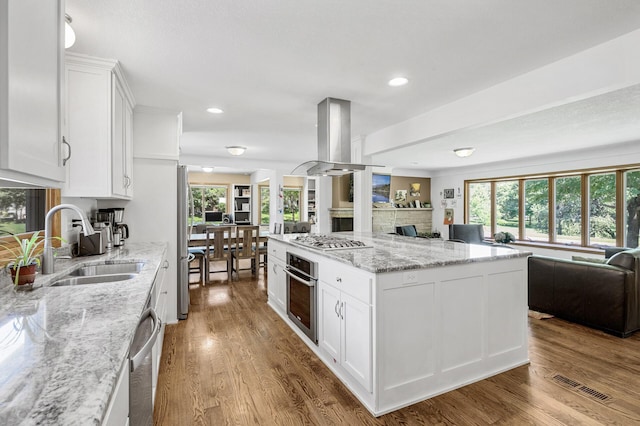 1281 Minnehaha Pkwy, Minneapolis, MN 55419 - kitchen with appliances with stainless steel finishes, open floor plan, island range hood, wood finished floors, and recessed lighting