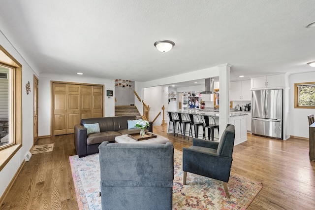 1281 Minnehaha Pkwy, Minneapolis, MN 55419 - living room with stairway, light wood-type flooring, a textured ceiling, and recessed lighting