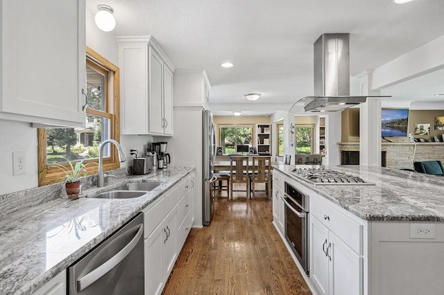 1281 Minnehaha Pkwy, Minneapolis, MN 55419 - kitchen featuring appliances with stainless steel finishes, exhaust hood, wood finished floors, white cabinetry, and light stone counters