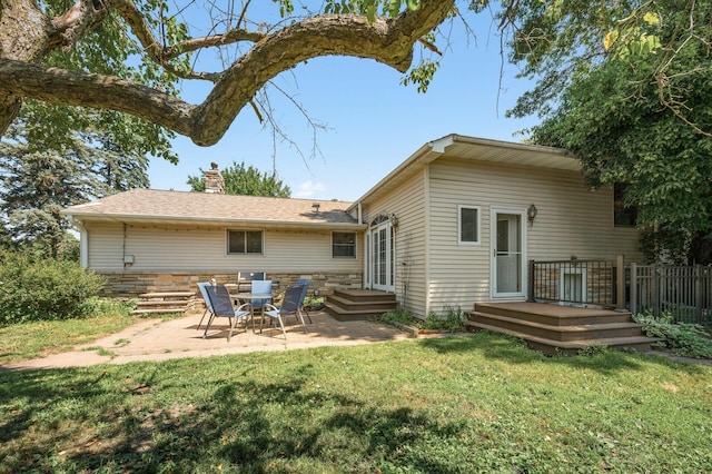 1281 Minnehaha Pkwy, Minneapolis, MN 55419 - back of house with a patio, a lawn, a chimney, a wooden deck, and stone siding