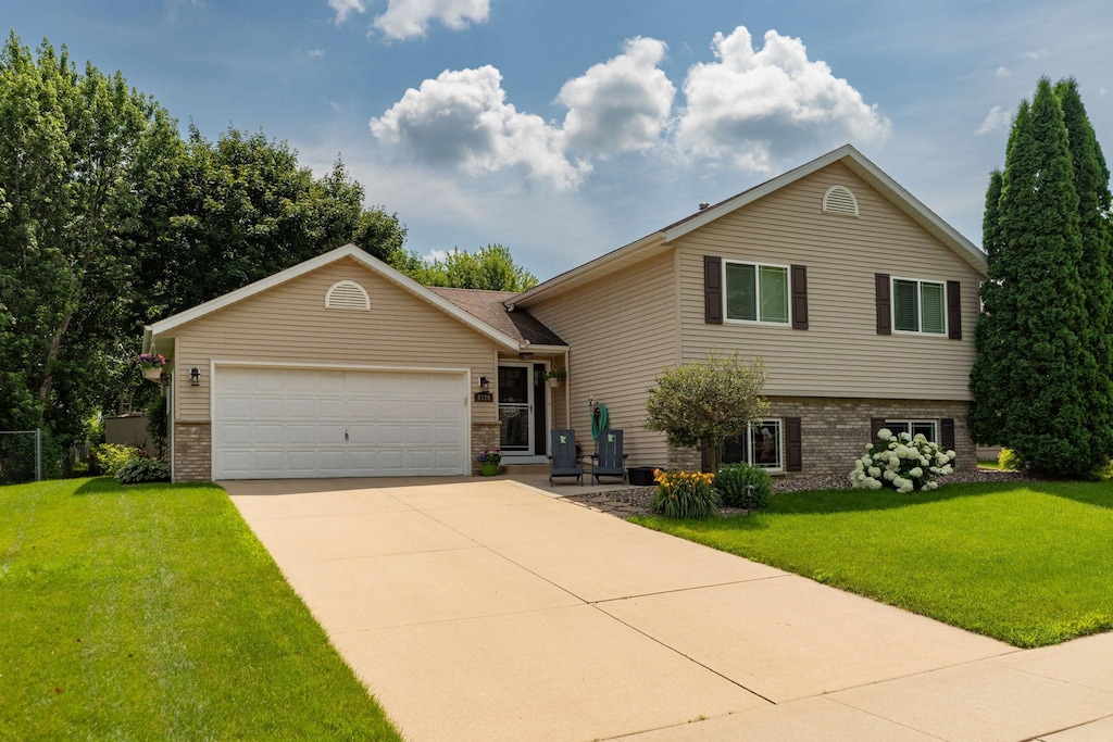 2720 20th Ave SE, Rochester, MN 55904 - tri-level home with brick siding, an attached garage, driveway, and a front lawn