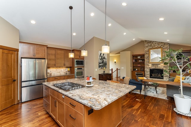 4089 Stone Point Dr NE, Rochester, MN 55906 - kitchen featuring appliances with stainless steel finishes, vaulted ceiling, dark wood finished floors, a kitchen island, and a stone fireplace