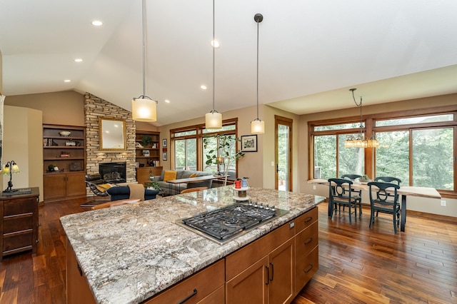 4089 Stone Point Dr NE, Rochester, MN 55906 - kitchen featuring stainless steel gas cooktop, dark wood-style flooring, light stone counters, a fireplace, and vaulted ceiling