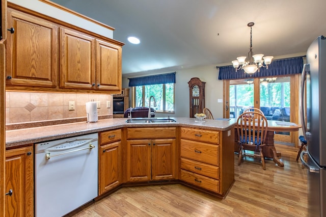5551 Nancy Ln NW, Rochester, MN 55901 - kitchen with dishwasher, freestanding refrigerator, a peninsula, brown cabinets, and a chandelier