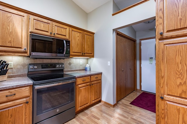 5551 Nancy Ln NW, Rochester, MN 55901 - kitchen featuring range with electric cooktop, light wood finished floors, backsplash, and brown cabinets