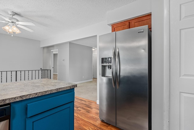 8210 Red Oak Dr, Mounds View, MN 55112 - kitchen with stainless steel fridge with ice dispenser, a ceiling fan, blue cabinets, light wood-style floors, and a textured ceiling