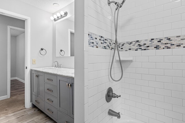 8210 Red Oak Dr, Mounds View, MN 55112 - bathroom featuring vanity, shower / bathtub combination, a textured ceiling, and wood finished floors