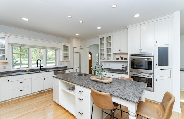 290 Wimbledon Hills Dr SW, Rochester, MN 55902 - kitchen featuring open shelves, stainless steel appliances, arched walkways, recessed lighting, and an island with sink