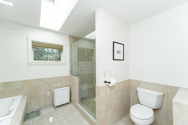 290 Wimbledon Hills Dr SW, Rochester, MN 55902 - bathroom featuring tile walls, tile patterned floors, a skylight, a bath, and a stall shower