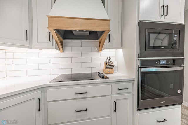 407 6th St NE, Barnesville, MN 56514 - kitchen featuring oven, extractor fan, built in microwave, black electric stovetop, and tasteful backsplash