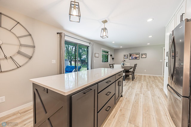 407 6th St NE, Barnesville, MN 56514 - kitchen with freestanding refrigerator, light wood finished floors, pendant lighting, recessed lighting, and a center island