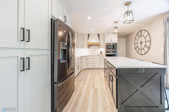 407 6th St NE, Barnesville, MN 56514 - kitchen featuring appliances with stainless steel finishes, custom exhaust hood, white cabinets, light countertops, and recessed lighting
