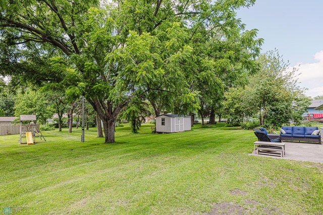 407 6th St NE, Barnesville, MN 56514 - view of grassy yard with an outdoor hangout area, a storage shed, a playground, and a patio area