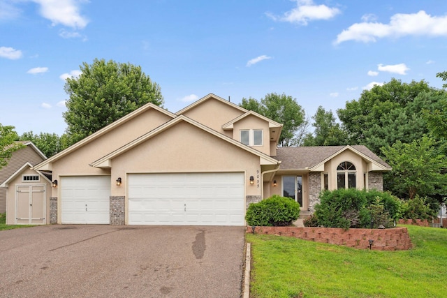 9055 Regent Pkwy, Brooklyn Park, MN 55443 - view of front facade featuring asphalt driveway, stucco siding, an attached garage, and a front lawn