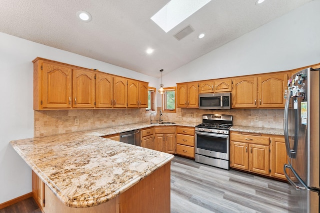 9055 Regent Pkwy, Brooklyn Park, MN 55443 - kitchen with appliances with stainless steel finishes, a peninsula, a skylight, lofted ceiling, and light wood finished floors