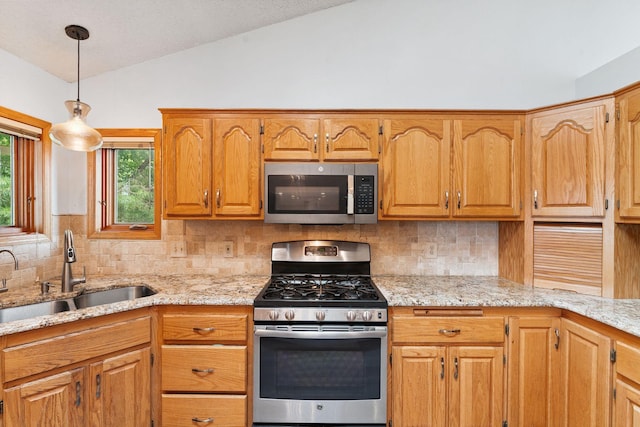9055 Regent Pkwy, Brooklyn Park, MN 55443 - kitchen with appliances with stainless steel finishes, vaulted ceiling, tasteful backsplash, pendant lighting, and light stone countertops