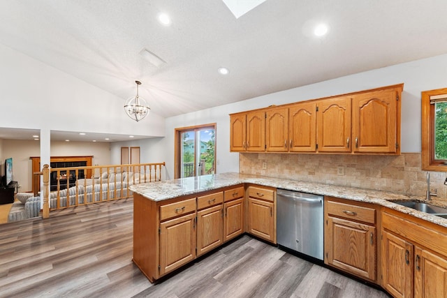9055 Regent Pkwy, Brooklyn Park, MN 55443 - kitchen featuring stainless steel dishwasher, a peninsula, vaulted ceiling, wood finished floors, and backsplash