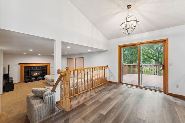 9055 Regent Pkwy, Brooklyn Park, MN 55443 - living area featuring wood finished floors, a chandelier, vaulted ceiling, a tiled fireplace, and recessed lighting