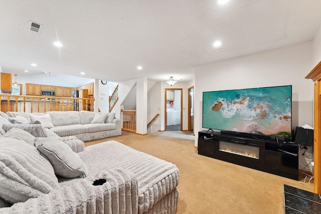 9055 Regent Pkwy, Brooklyn Park, MN 55443 - living area featuring washer / dryer, light colored carpet, recessed lighting, stairway, and a glass covered fireplace
