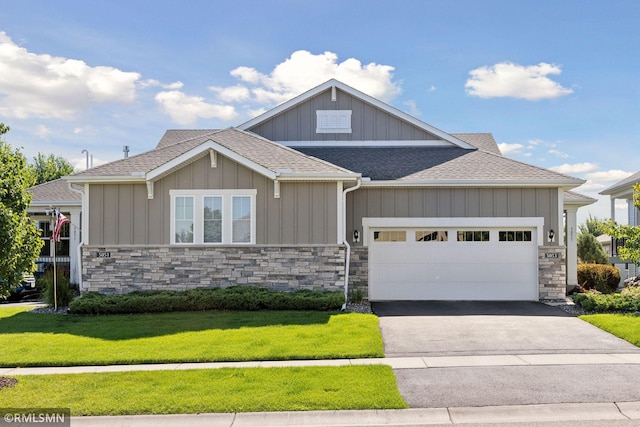 5053 Sunstream Ln, Woodbury, MN 55129 - craftsman-style home with a shingled roof, a front yard, driveway, and stone siding