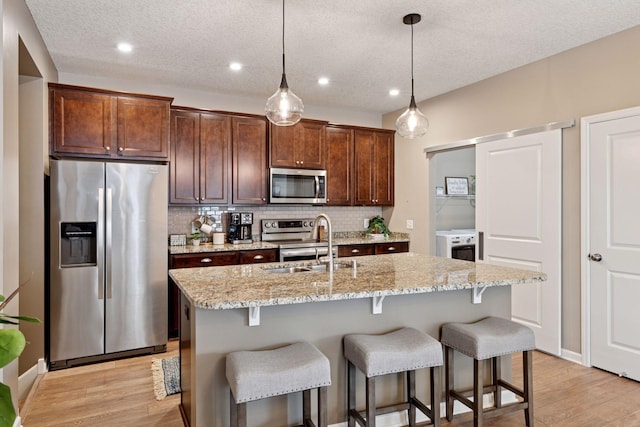 5053 Sunstream Ln, Woodbury, MN 55129 - kitchen with appliances with stainless steel finishes, backsplash, a breakfast bar, light wood-style flooring, and recessed lighting