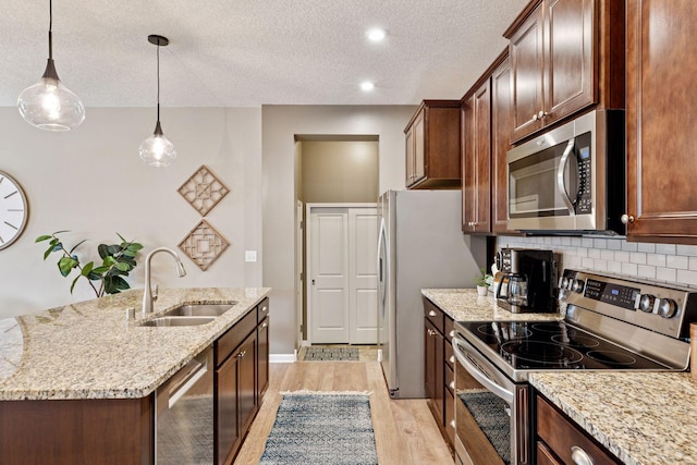 5053 Sunstream Ln, Woodbury, MN 55129 - kitchen with stainless steel appliances, tasteful backsplash, light wood-type flooring, an island with sink, and light stone counters