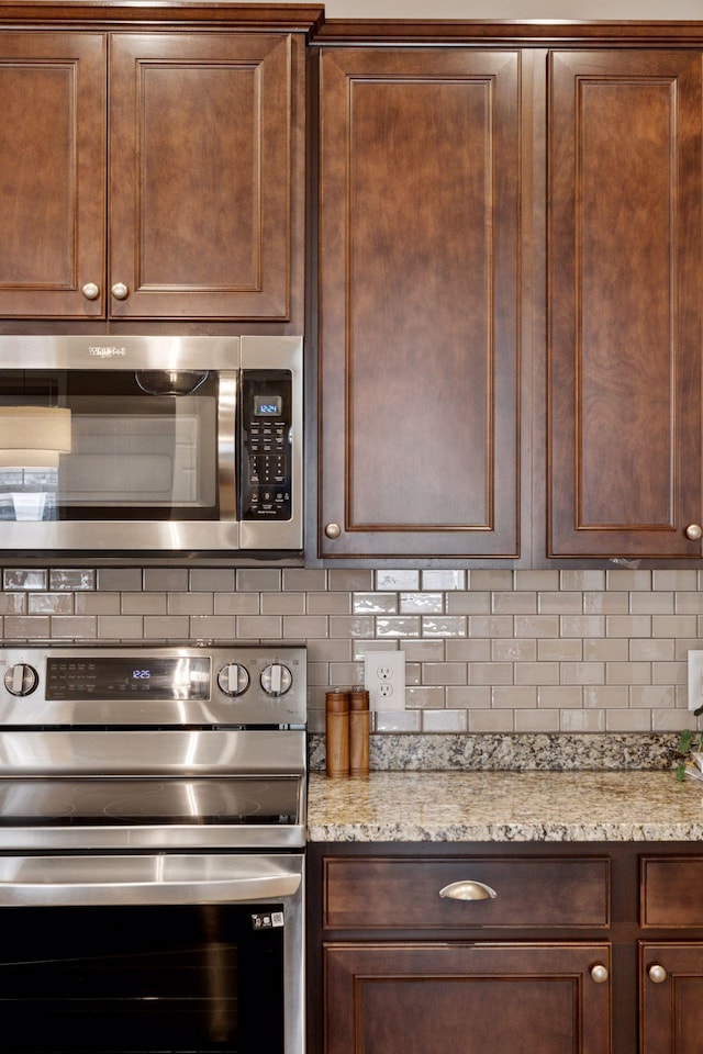 5053 Sunstream Ln, Woodbury, MN 55129 - kitchen featuring stainless steel appliances, decorative backsplash, and light stone counters