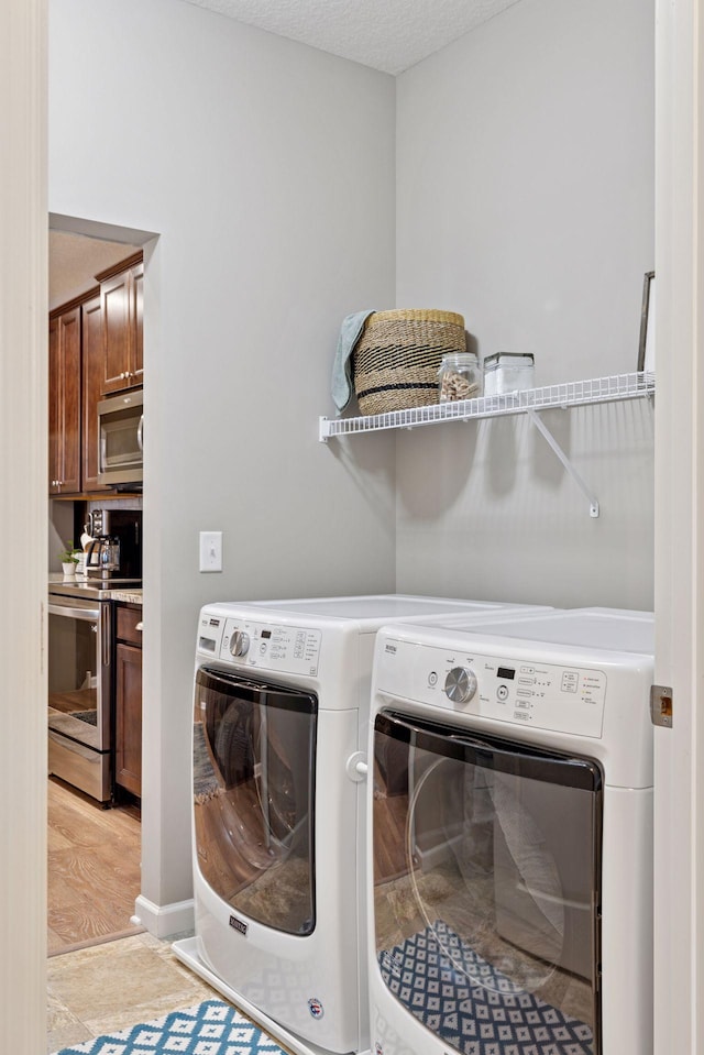 5053 Sunstream Ln, Woodbury, MN 55129 - laundry room with washer and clothes dryer and light wood-type flooring