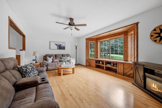 13326 Mallard Dr SE, Becker Twp, MN 55308 - living area with ceiling fan, light wood finished floors, and a glass covered fireplace