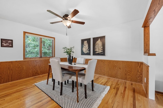 13326 Mallard Dr SE, Becker Twp, MN 55308 - dining space featuring a wainscoted wall, light wood-type flooring, a ceiling fan, and wooden walls