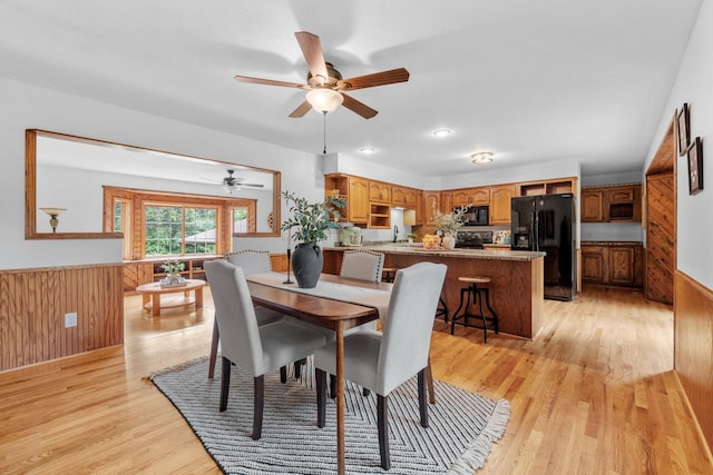 13326 Mallard Dr SE, Becker Twp, MN 55308 - dining area with a ceiling fan, light wood-style flooring, wainscoting, and wooden walls
