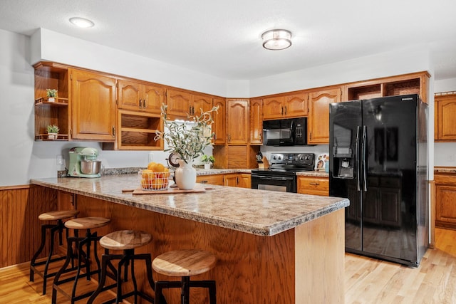 13326 Mallard Dr SE, Becker Twp, MN 55308 - kitchen featuring black appliances, open shelves, light wood-style flooring, and a peninsula