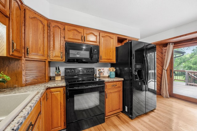 13326 Mallard Dr SE, Becker Twp, MN 55308 - kitchen with black appliances, light wood-type flooring, and brown cabinetry
