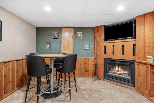13326 Mallard Dr SE, Becker Twp, MN 55308 - bar area with wooden walls, a glass covered fireplace, a paneled ceiling, recessed lighting, and wainscoting