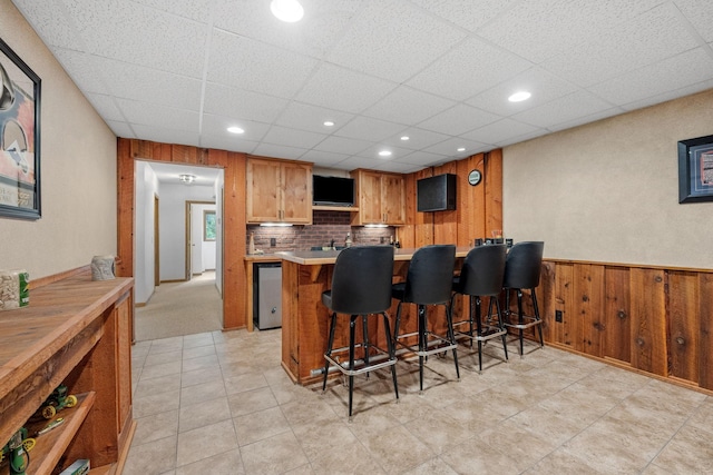 13326 Mallard Dr SE, Becker Twp, MN 55308 - kitchen with a breakfast bar, light countertops, a drop ceiling, a peninsula, and a wainscoted wall